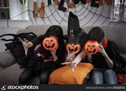 Group of girl and boy kids dress up costume and hold the pumpkin bowl at face for trick or treat for Halloween day theme coming soon together