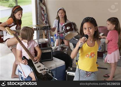 Group of girls (7-9) with instruments in garage