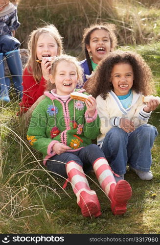 Group Of Girls Eating Cream Cakes In Field Together