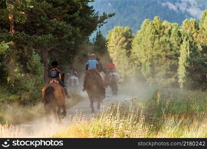 Group of girls on horseback during riding school on a dirt road