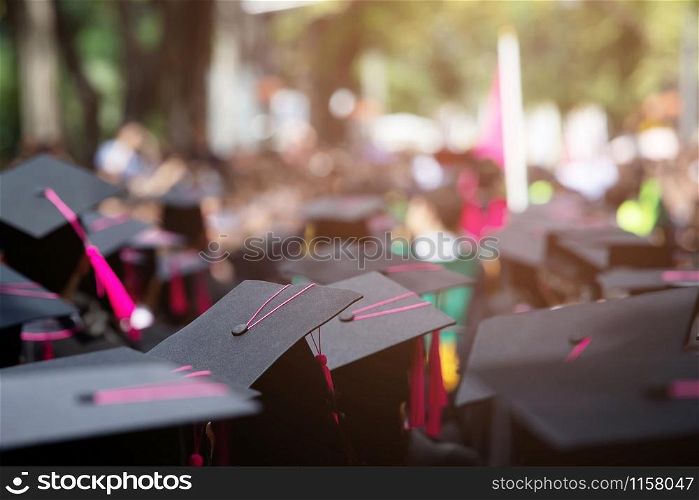 Group of Graduates during commencement. Concept education congratulation in University Degree. Graduation Ceremony. focus tassel pink.