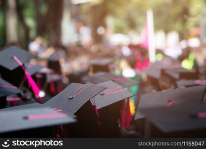 Group of Graduates during commencement. Concept education congratulation in University Degree. Graduation Ceremony. focus tassel pink.