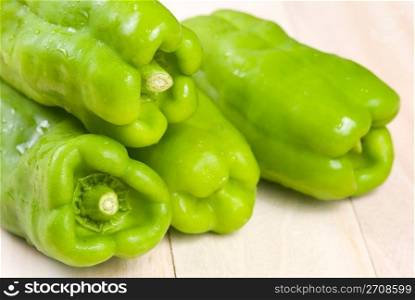 group of green bell peppers on wooden background