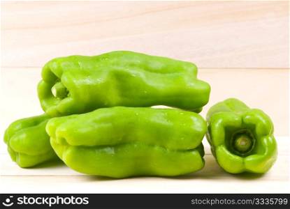 group of green bell peppers on wooden background