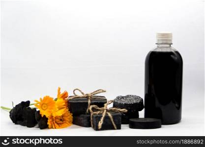 group of handmade cosmetics with activated carbon and calendula and lavender flowers. group of handmade cosmetics with activated carbon
