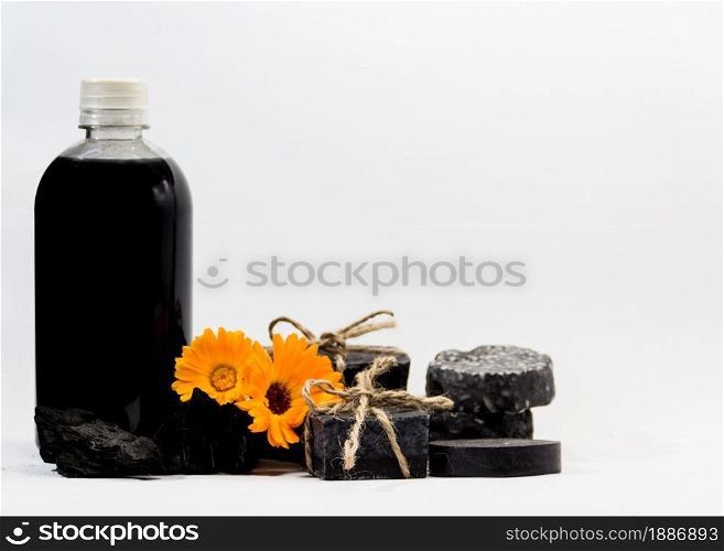 group of handmade cosmetics with activated carbon and calendula and lavender flowers. group of handmade cosmetics with activated carbon