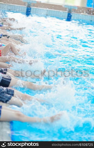 group of happy kids children at swimming pool class learning to swim