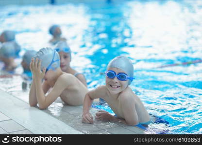 group of happy kids children at swimming pool class learning to swim