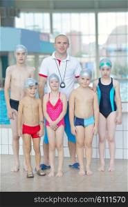 group of happy kids children at swimming pool class learning to swim
