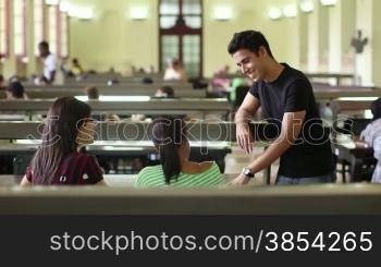 Group of happy students and friends studying at school, young men and women meeting and talking in college library, University of Havana, Cuba