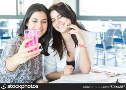 Group of happy students preparing their exams or simply relaxing at a bar