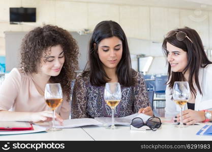 Group of happy students preparing their exams or simply relaxing at a bar