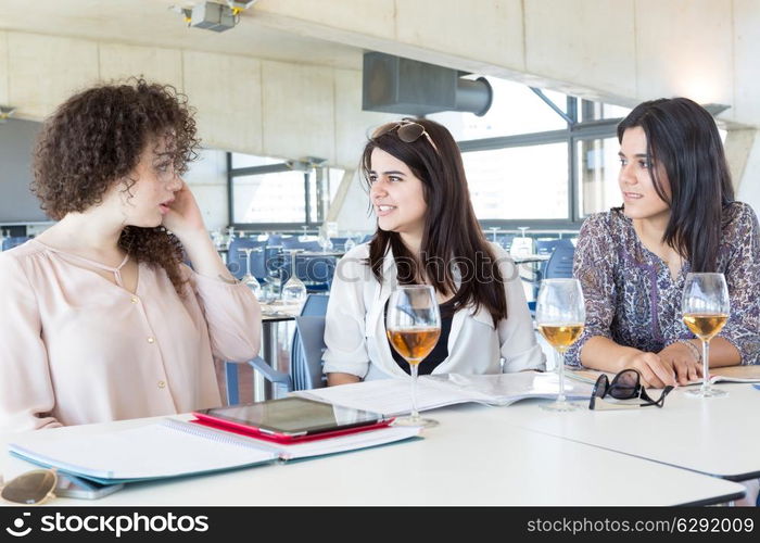 Group of happy students preparing their exams or simply relaxing at a bar