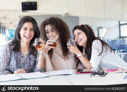 Group of happy students preparing their exams or simply relaxing at a bar