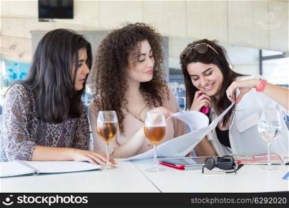 Group of happy students preparing their exams or simply relaxing at a bar