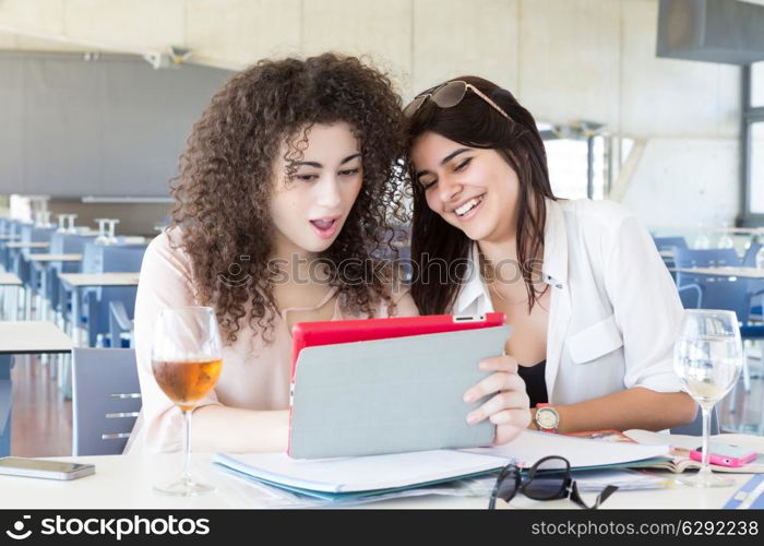 Group of happy students preparing their exams or simply relaxing at a bar