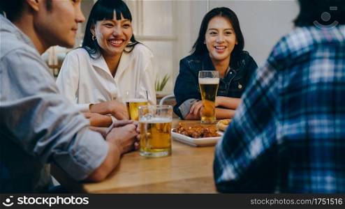 Group of happy tourist young Asian friend drinking alcohol beer and having fun laugh enjoy hangout party in night club at Khao San Road. Traveler backpacker Asia people travel in Bangkok, Thailand.
