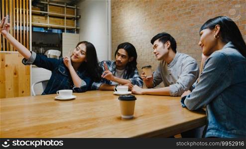 Group of happy young Asia people having fun a great time and making selfie with her friend while sitting together at cafe restaurant. Coffee shop holiday activity, modern friendship lifestyle concept.