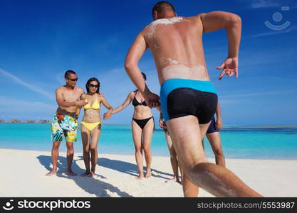 group of happy young people have fun and joy at the white sand beach on beautiful summer day