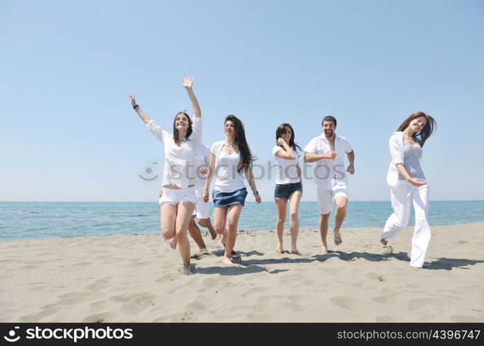 Group of happy young people in circle at beach have fun