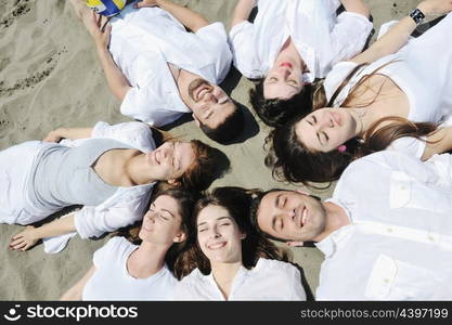 Group of happy young people in circle at beach have fun