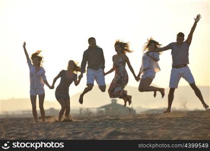 Group of happy young people in circle at beach have fun