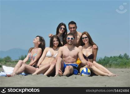 Group of happy young people in circle at beach have fun