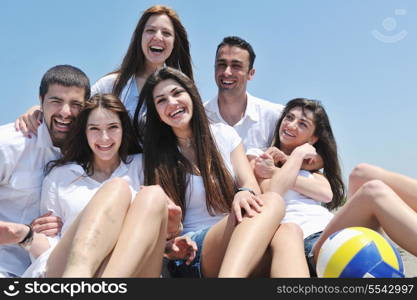 Group of happy young people in circle at beach have fun