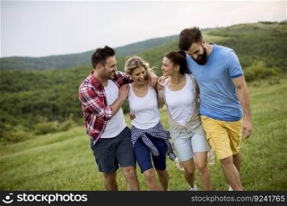 Group of happy young people walking in the summer field