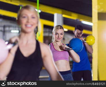 group of healthy young athletes doing exercises with kettlebells at crossfitness studio. athletes doing exercises with kettlebells