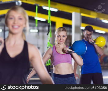 group of healthy young athletes doing exercises with kettlebells at crossfitness studio. athletes doing exercises with kettlebells