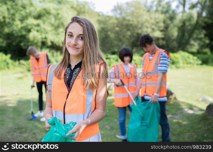 Group Of Helpful Teenagers Collecting Litter In Countryside