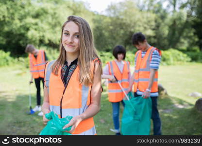 Group Of Helpful Teenagers Collecting Litter In Countryside