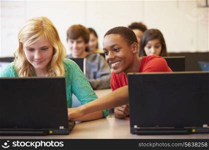 Group Of High School Students In Class Using Laptops