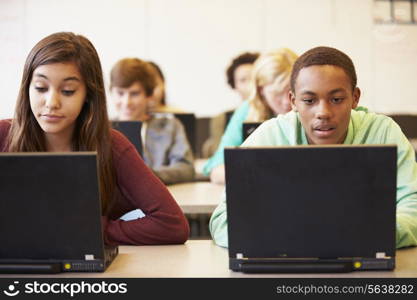 Group Of High School Students In Class Using Laptops