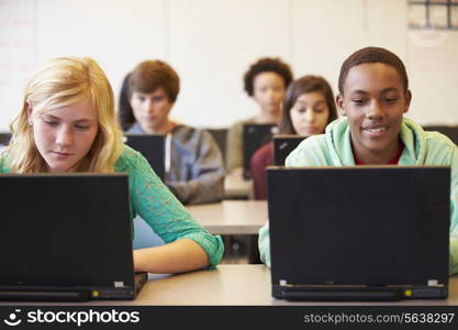 Group Of High School Students In Class Using Laptops