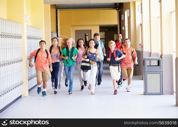 Group Of High School Students Running Along Corridor