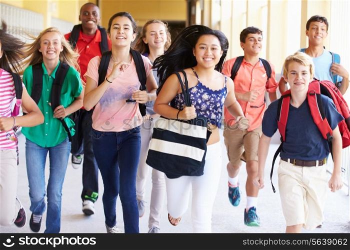 Group Of High School Students Running Along Corridor