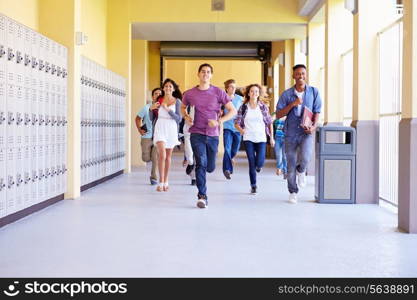 Group Of High School Students Running In Corridor