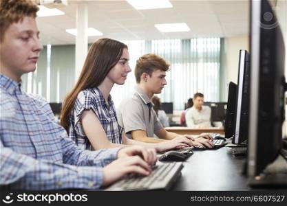 Group Of High School Students Working Together In Computer Class