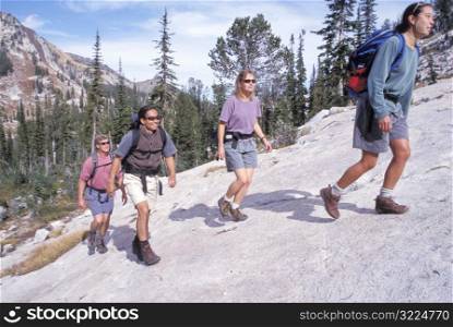 Group Of Hikers Walking Up A Steep Mountain Rock