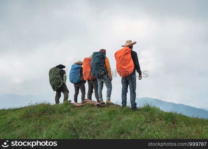 Group of hiking adventures standing on a ridge. Clear weather, clear sky