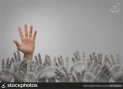 Group of human hands raised high up on grey background. Concept Business