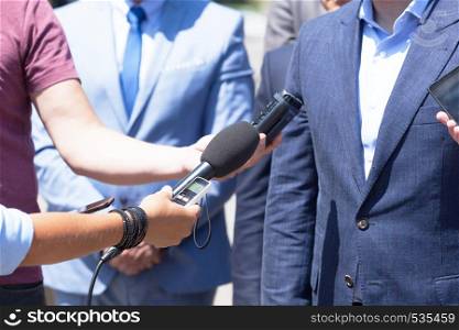 Group of journalists recording speech of business person or politician during press conference