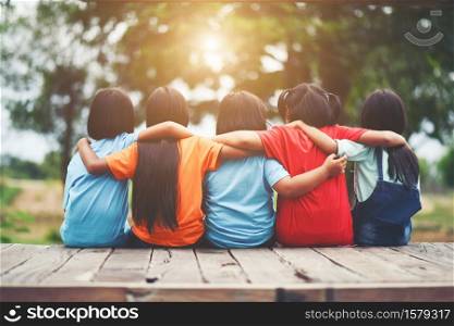 Group of kids friends arm around sitting together