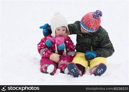 group of kids having fun and play together in fresh snow on winter vacation