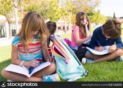 Group of little students sitting on the grass at school