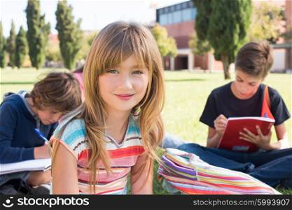 Group of little students sitting on the grass at school