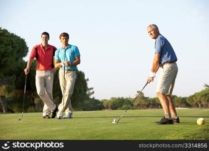 Group Of Male Golfers Teeing Off On Golf Course