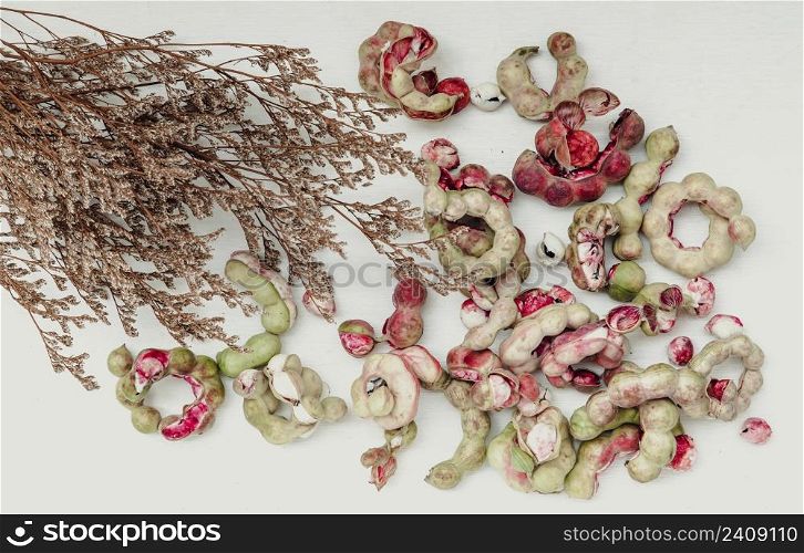 Group of Manila tamarind fruit or Pithecellobium dulce is another type of Thai herb with Dried flowers on white background. Selective focus.